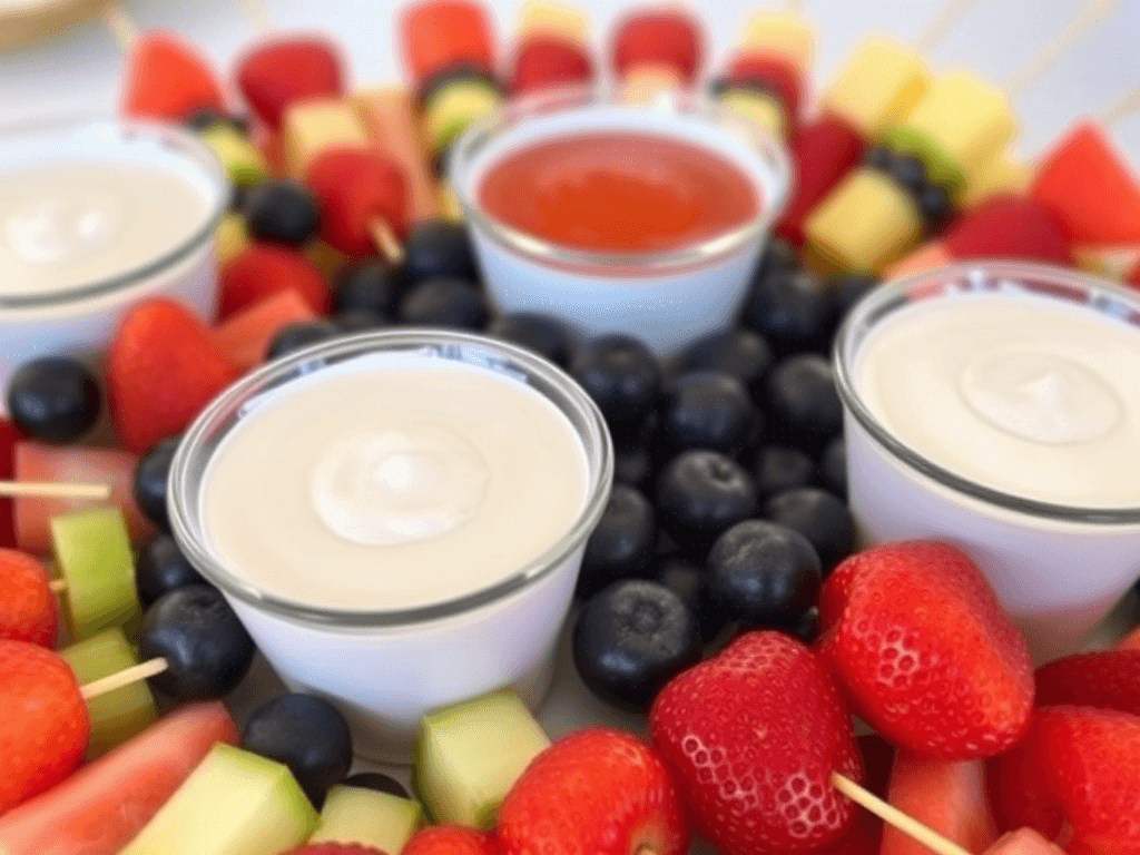 Elegant fruit tray with individual fruit dip cups and fruit skewers.